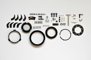 Leistungen Organized layout of mechanical parts on a white surface, ideal for tech and engineering themes.