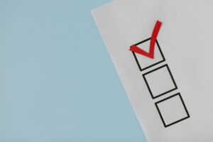 Leistungen A simple white paper checklist with one red checkmark, ideal for concepts like completion or approval.